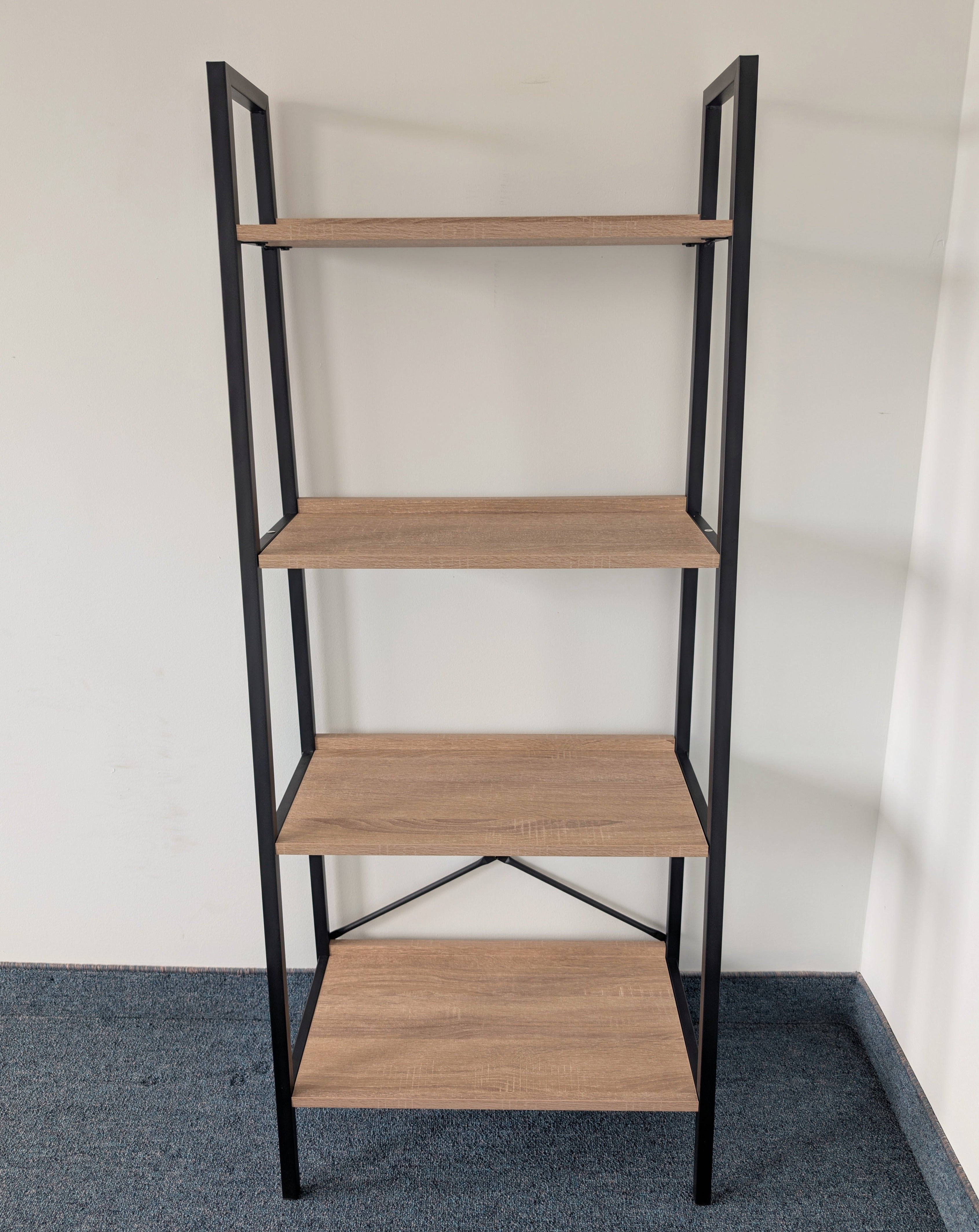 Bookshelf with wooden shelves and black metal frame against a plain wall.