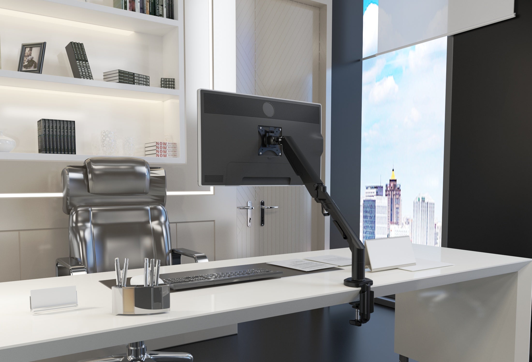Modern office desk setup with computer monitor, keyboard, and chair in a bright room.