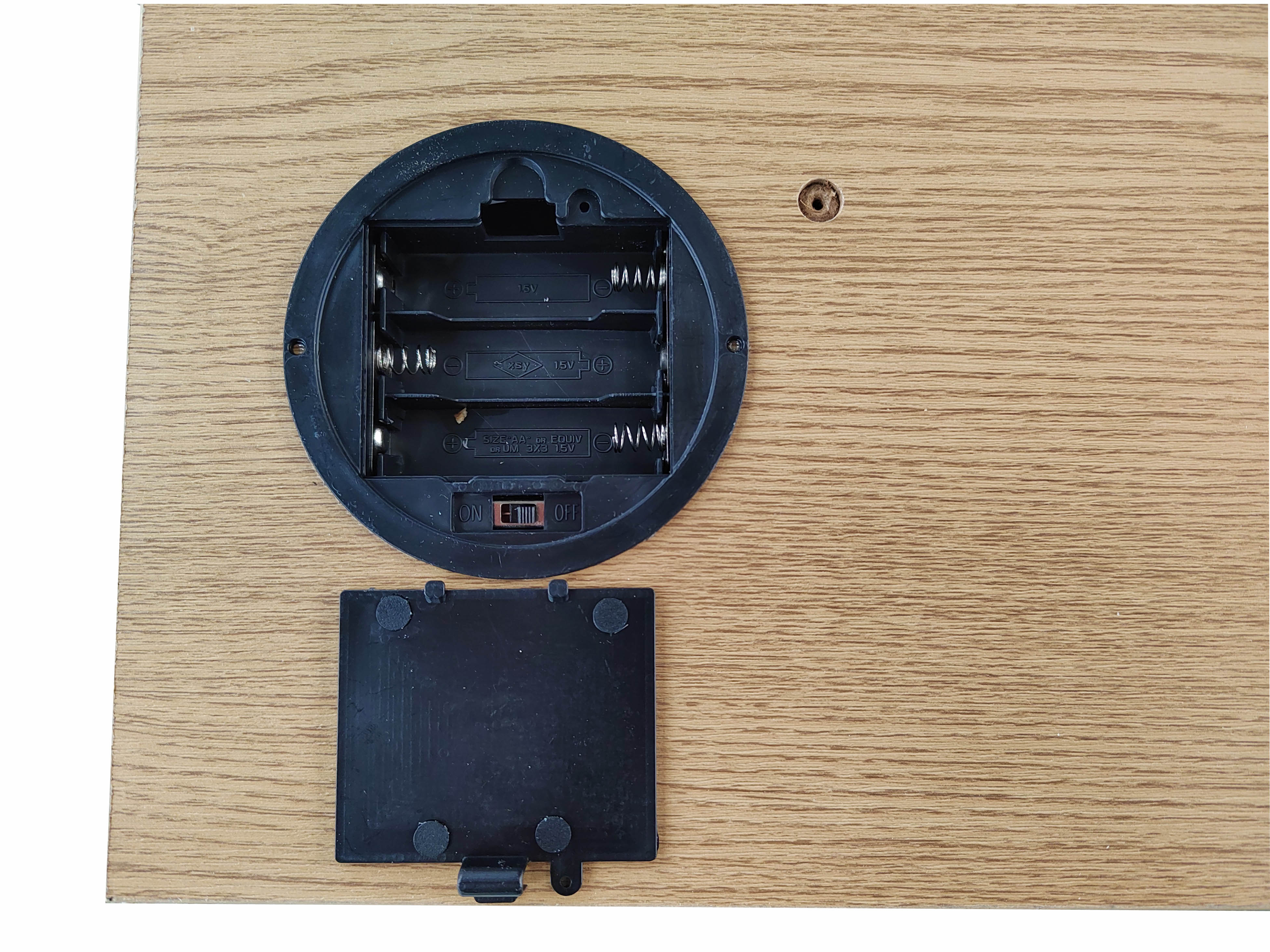 Black plastic component on a wooden surface