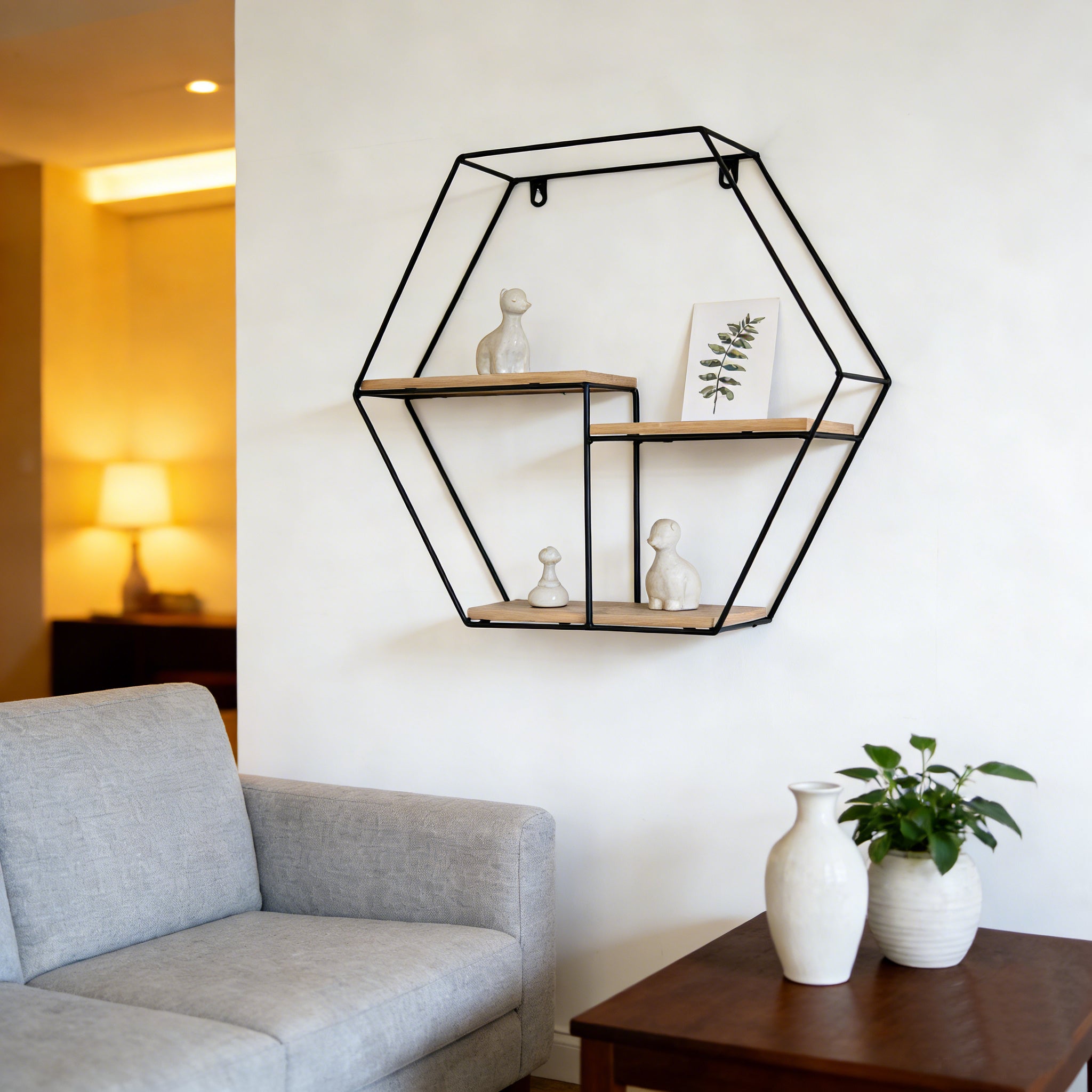 Hexagonal wall shelf in a living room setting with a gray sofa and wooden coffee table.