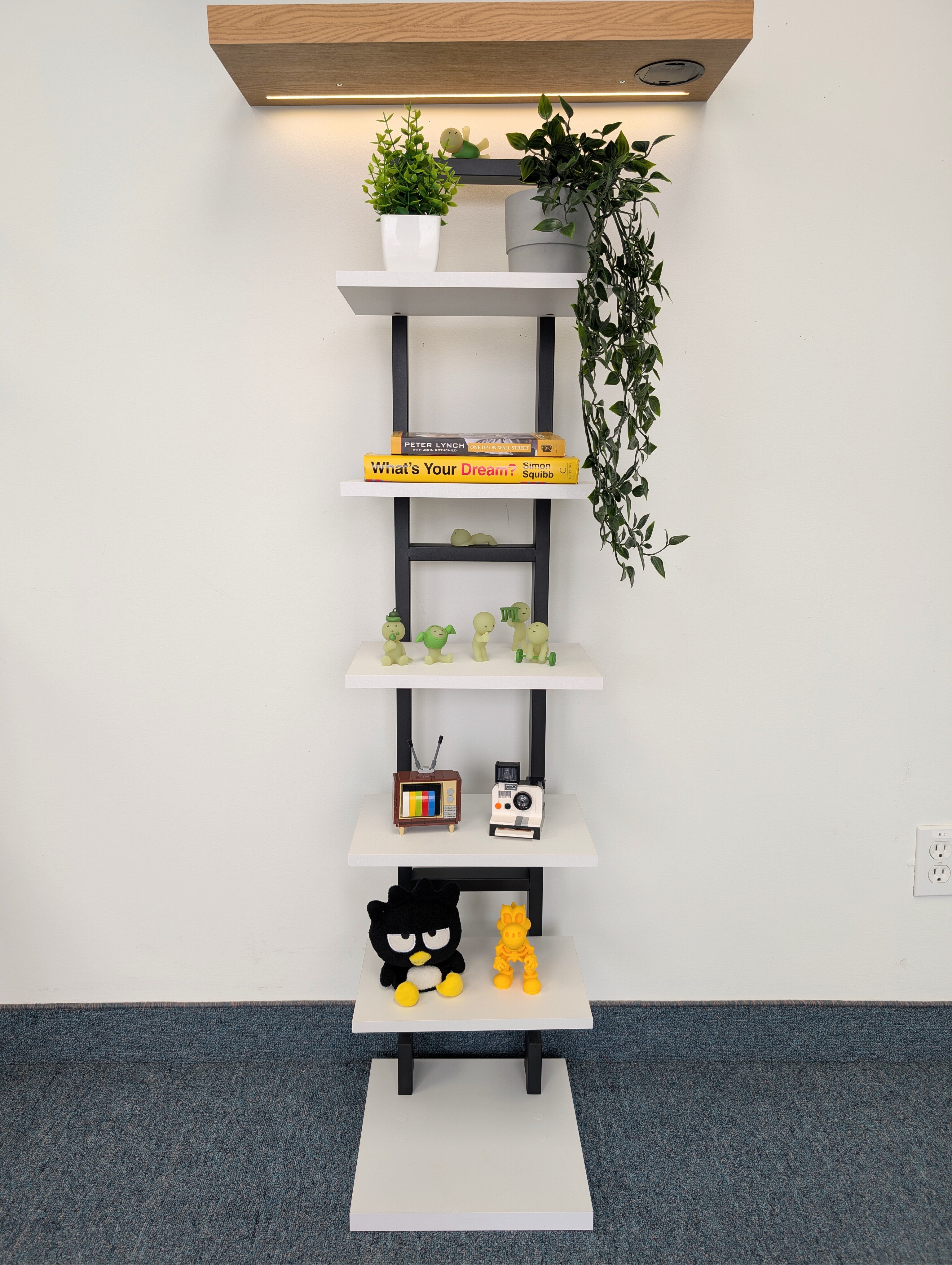 Tall white shelf with decorative items against a white wall