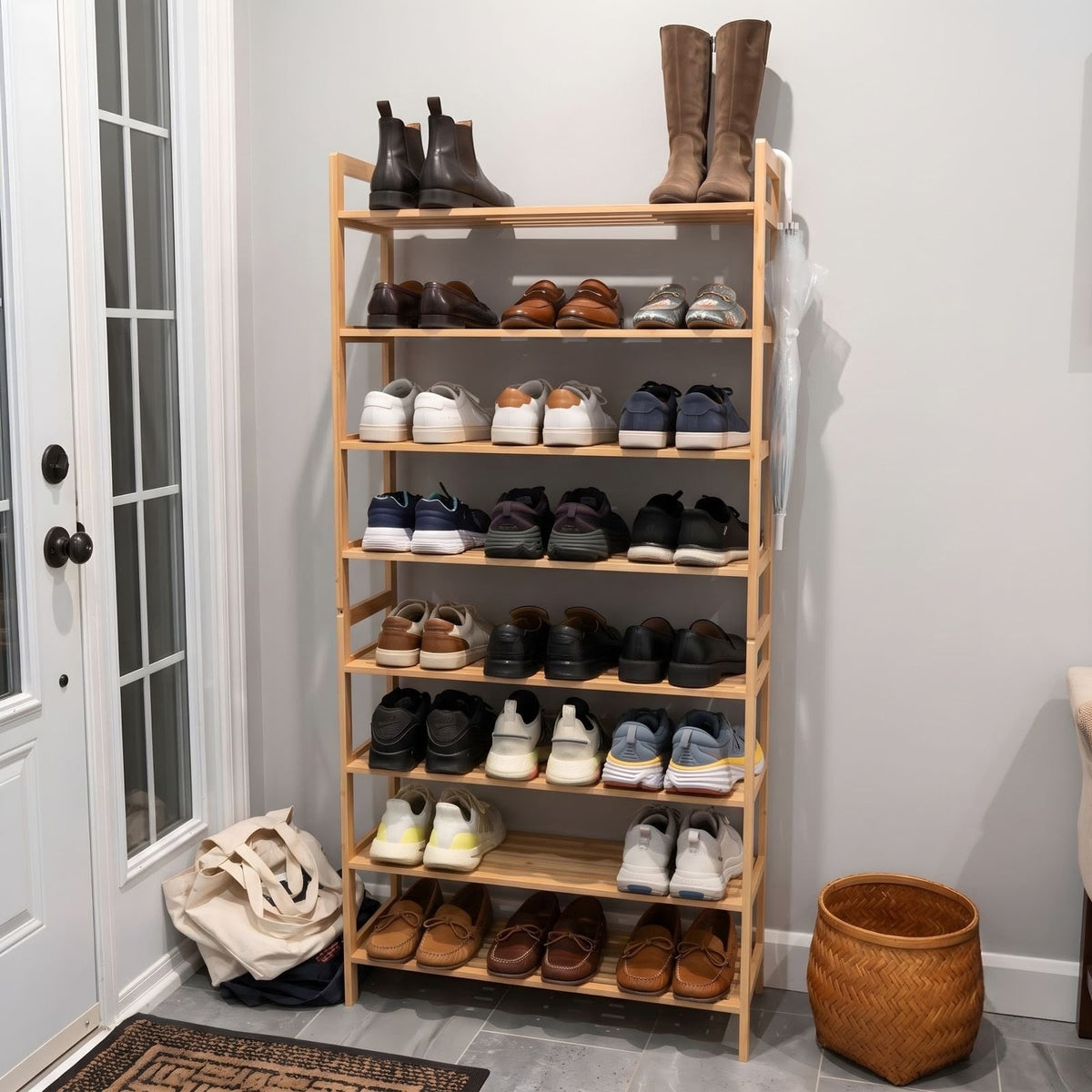 A tall, wooden shoe rack filled with various shoes, boots, and sneakers, set in a home entryway next to a glass-paneled door.
