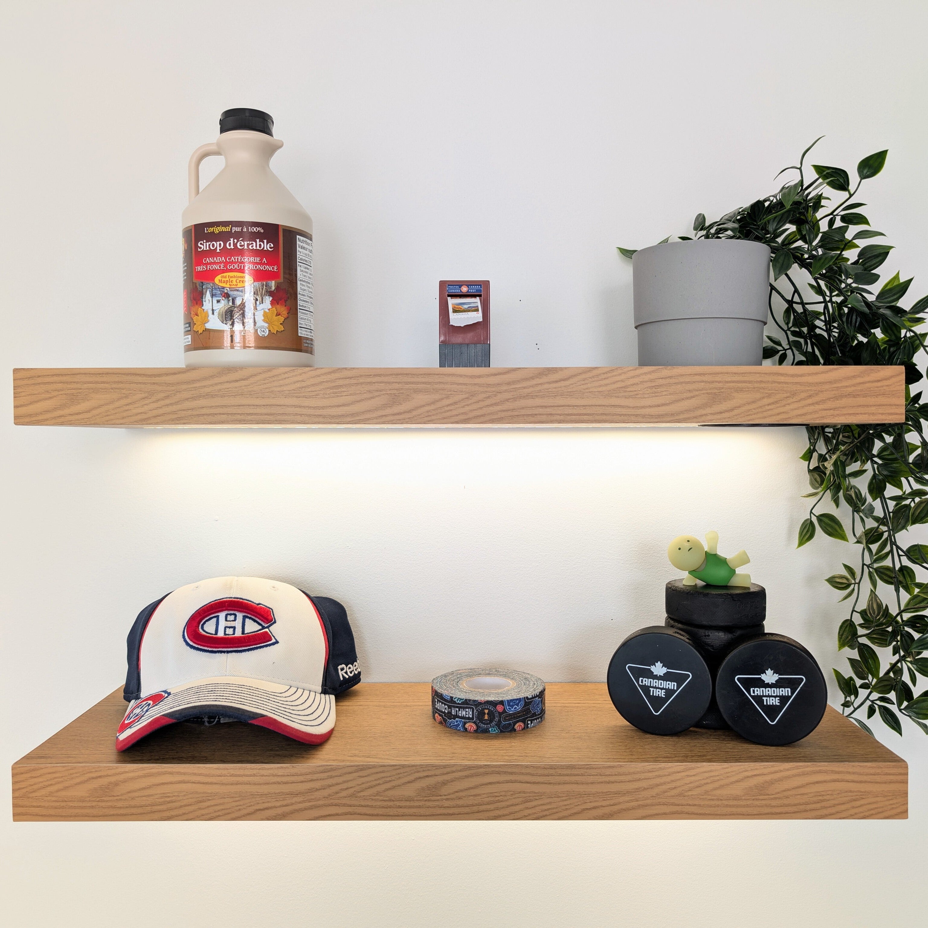 Wooden shelves with a Montreal Canadiens cap, bottle, and decorative items against a white wall.