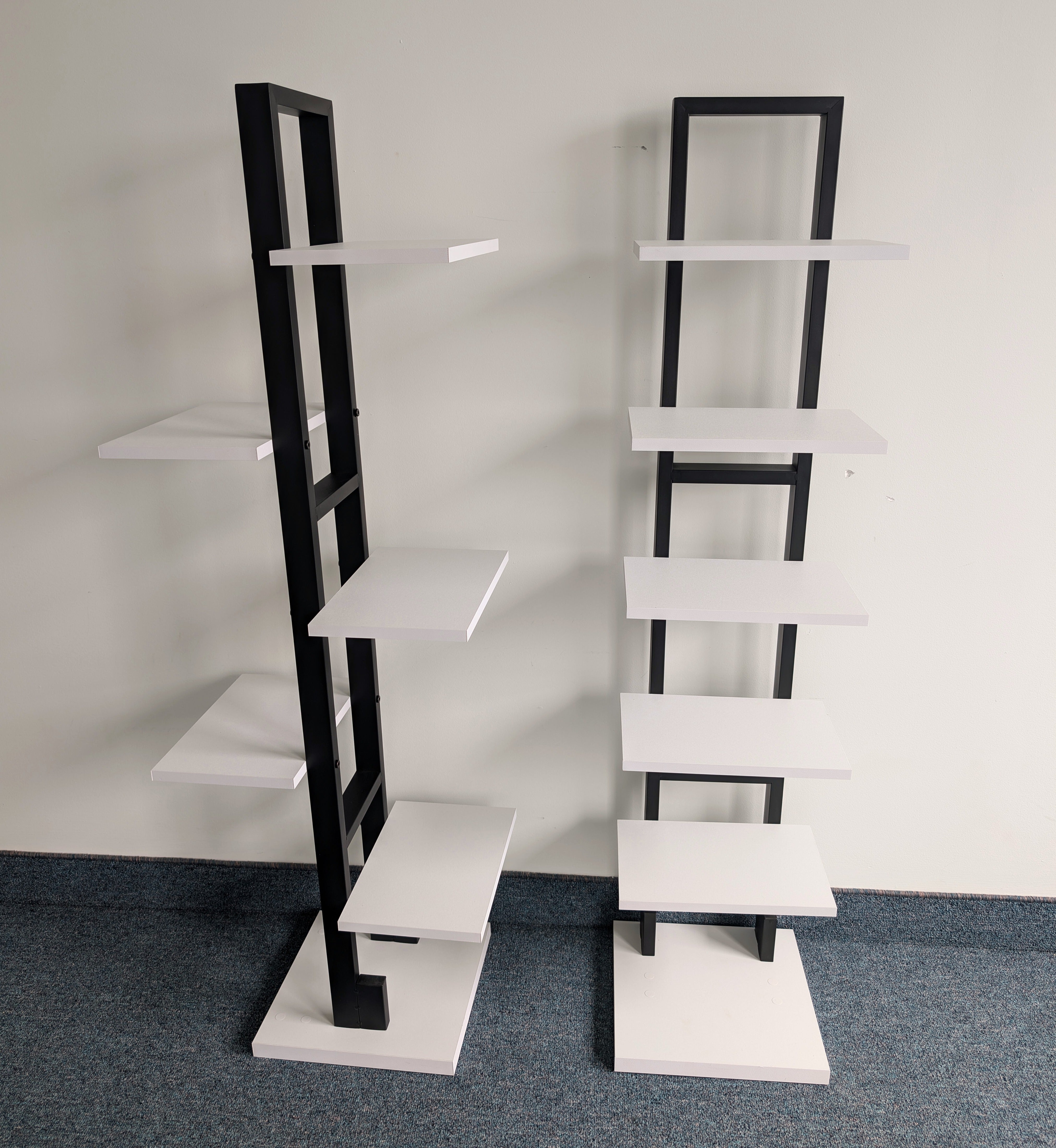 Two black and white bookshelves against a plain wall.