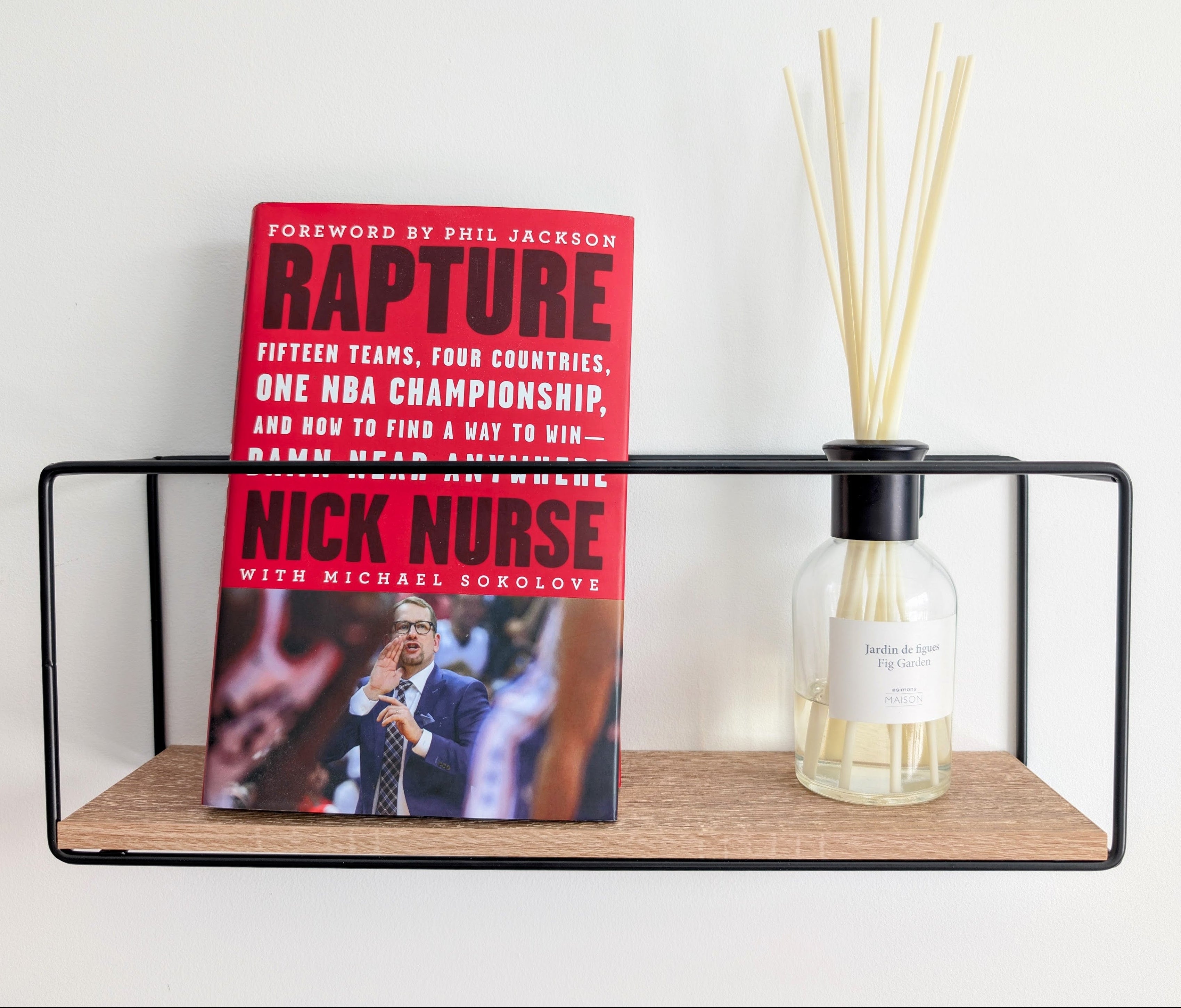 Book titled 'Rapture' by Nick Nurse with a diffuser on a shelf.